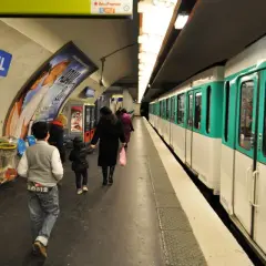 Na stacji Miromesnil w Paryżu widać pociąg metra. Ludzie czekają na peronie, a mapa metra wisi na ścianie.