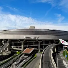 Terminal 1 na lotnisku Paryż-Charles de Gaulle, z charakterystyczną, okrągłą architekturą i drogami prowadzącymi do niego.