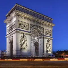 Łuk Triumfalny w Paryżu o zmierzchu, z widoczną w oddali Wieżą Eiffla.