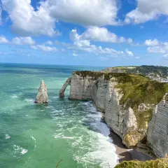 Klify w Étretat, Normandia: białe skały, łuk skalny i iglica w zielonym morzu.