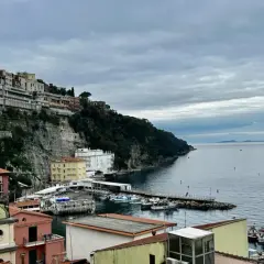 Widok na malownicze miasteczko na klifie i port w Sorrento. Warto zobaczyć te kolorowe domy i błękitne morze.
