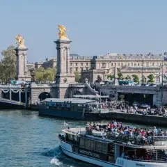Rejs po Sekwanie, cena atrakcyjna! Statek z turystami płynie pod mostem Aleksandra III w Paryżu.