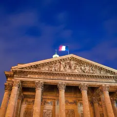 Panteon w Paryżu, symbol tego, z czego słynie Francja: wielkości i sztuki. Flaga Francji powiewa na tle nocnego nieba.