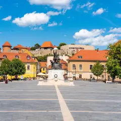 Rynek w Egerze z pomnikiem i zamkiem w tle. Odkryj atrakcje Egeru i okolic!