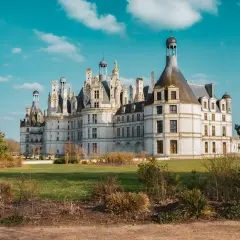 Kobieta podziwia majestatyczny zamek na wodzie we Francji.