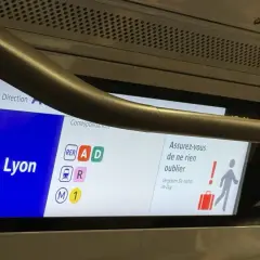 Wyświetlacz w pociągu RER z informacją o stacji Gare de Lyon i symbolami linii.