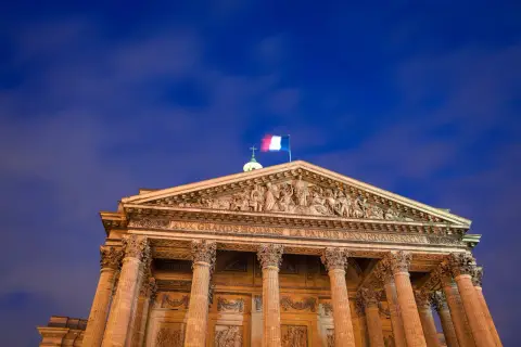 Panteon w Paryżu, symbol tego, z czego słynie Francja: wielkości i sztuki. Flaga Francji powiewa na tle nocnego nieba.