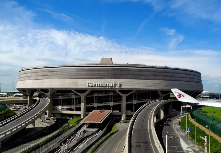 Terminal 1 na lotnisku Paryż-Charles de Gaulle, z charakterystyczną, okrągłą architekturą i drogami prowadzącymi do niego.