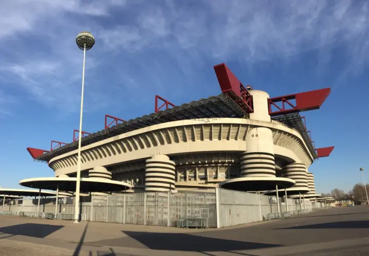 Stadion San Siro z czerwonymi elementami dachu i charakterystycznymi wieżami. Marzenie o meczu i zakup san siro bilety.