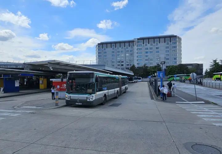 Paryż lotnisko Charles de Gaulle: autobusy i ludzie czekają na transport do centrum. W tle hotel Hilton.