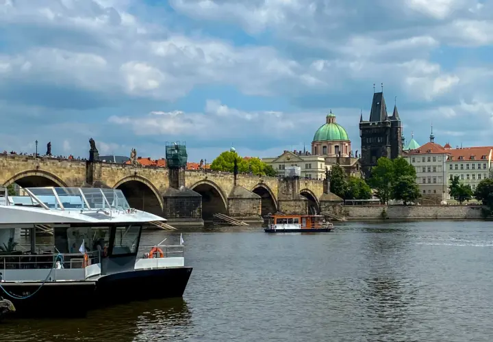 Rejs po Wełtawie czy warto? Widok na Most Karola z łodzią turystyczną.
