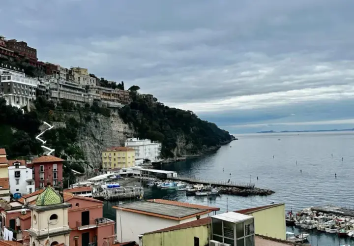 Widok na malownicze miasteczko na klifie i port w Sorrento. Warto zobaczyć te kolorowe domy i błękitne morze.