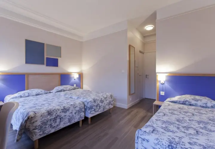 Pokój z trzema łóżkami w hotelu, idealny na paryż tanie noclegi u sióstr. Wygodne, przytulne wnętrze.