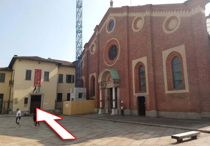 Plac przed kościołem, gdzie można kupić bilety na Ostatnią Wieczerzę. W tle budynek z banerem "Cenacolo Vinciano".