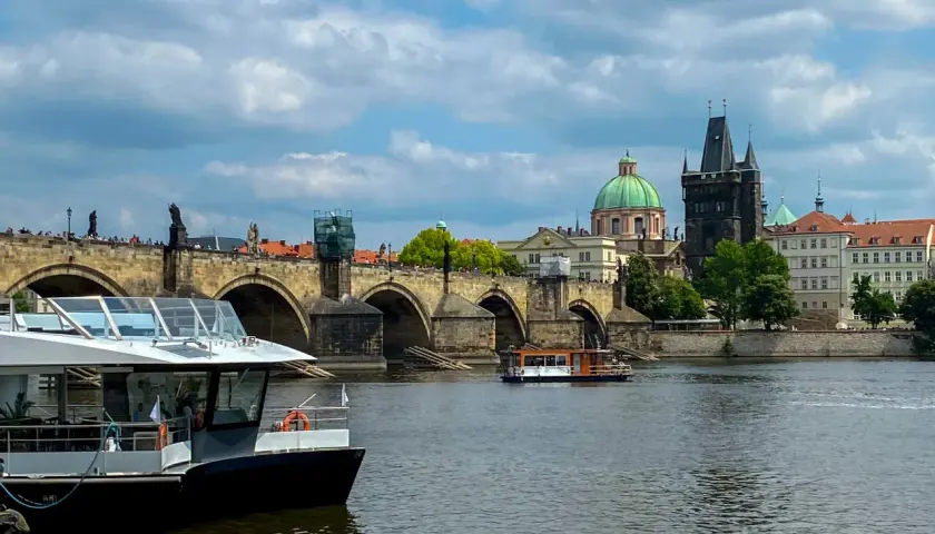 Rejs po Wełtawie czy warto? Widok na Most Karola z łodzią turystyczną.