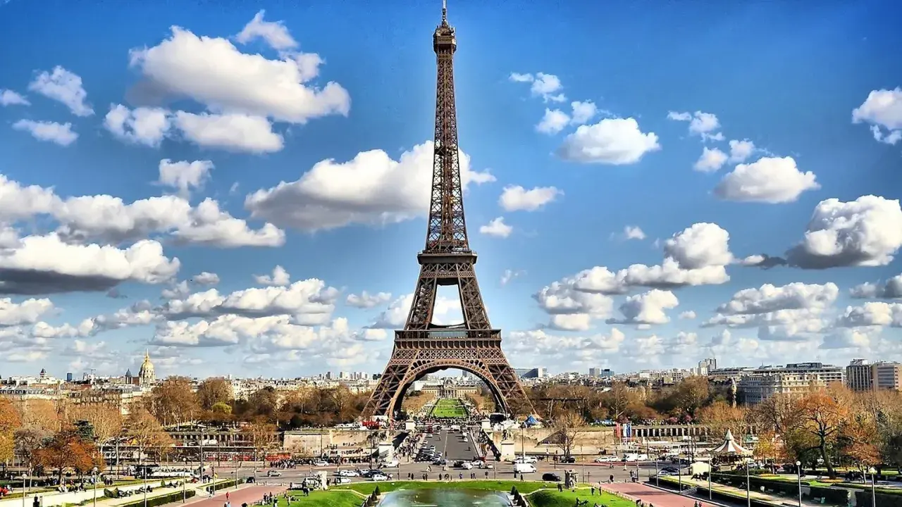 Wieża Eiffla w Paryżu, widok z dołu. W tle miasto i chmury. Ceny w Paryżu mogą być wysokie, ale widoki są bezcenne.