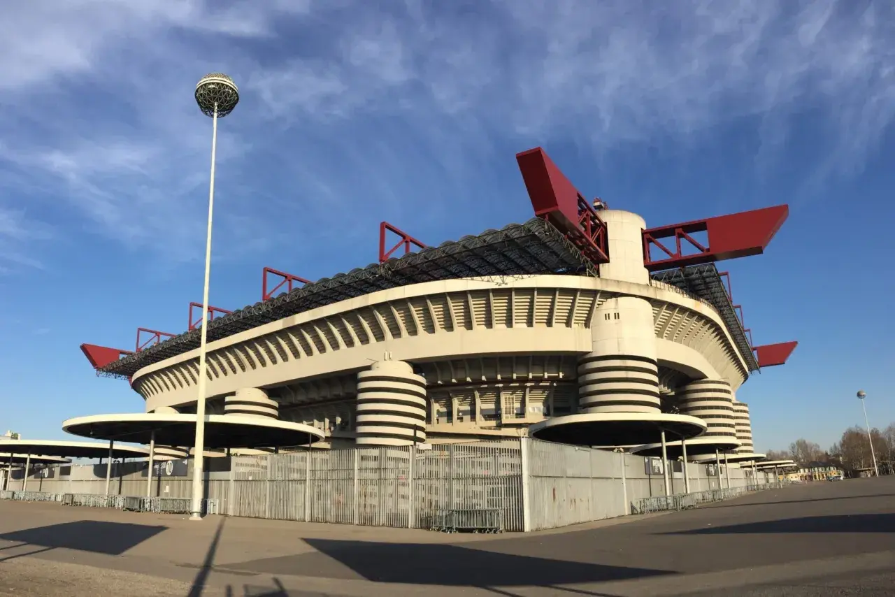 Stadion San Siro z czerwonymi elementami dachu i charakterystycznymi wieżami. Marzenie o meczu i zakup san siro bilety.
