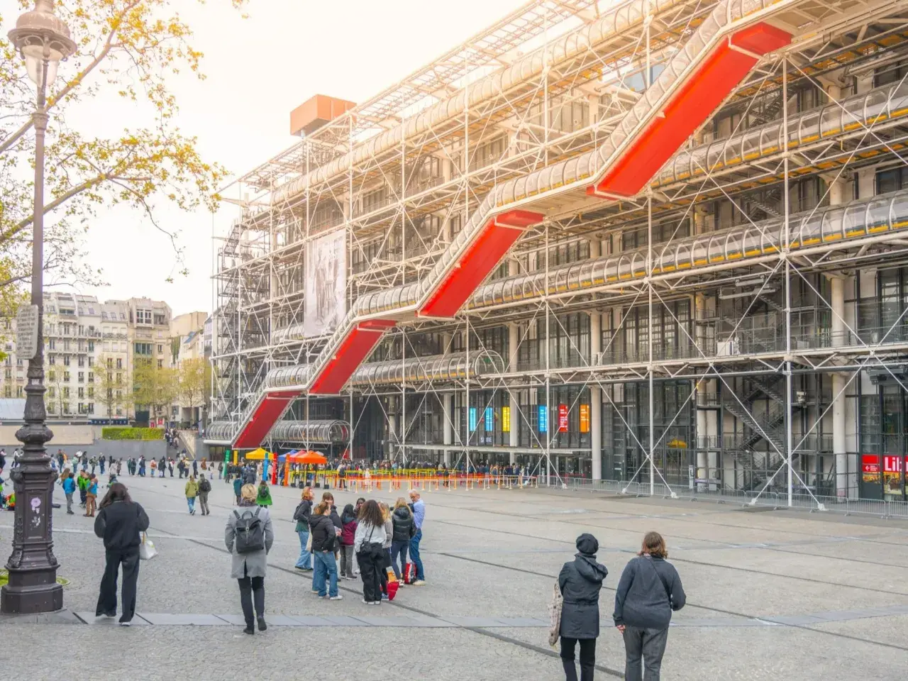 Centrum Pompidou z czerwonymi schodami i ludźmi na placu.