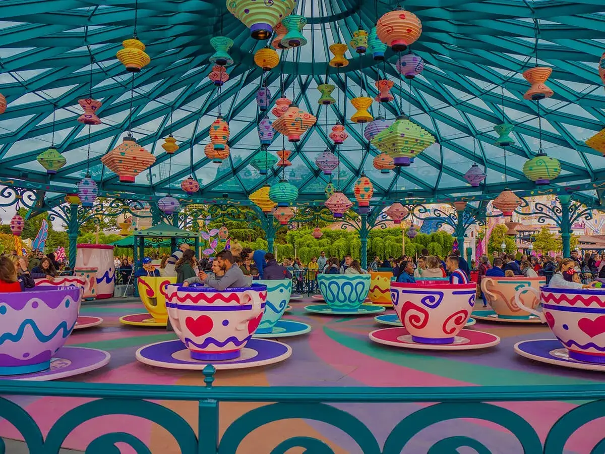 Kolorowa karuzela w kształcie filiżanek w Disneylandzie w Europie, z mnóstwem wiszących lampionów.