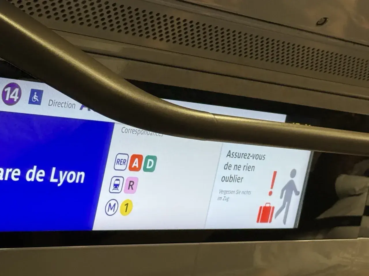 Wyświetlacz w pociągu RER z informacją o stacji Gare de Lyon i symbolami linii.