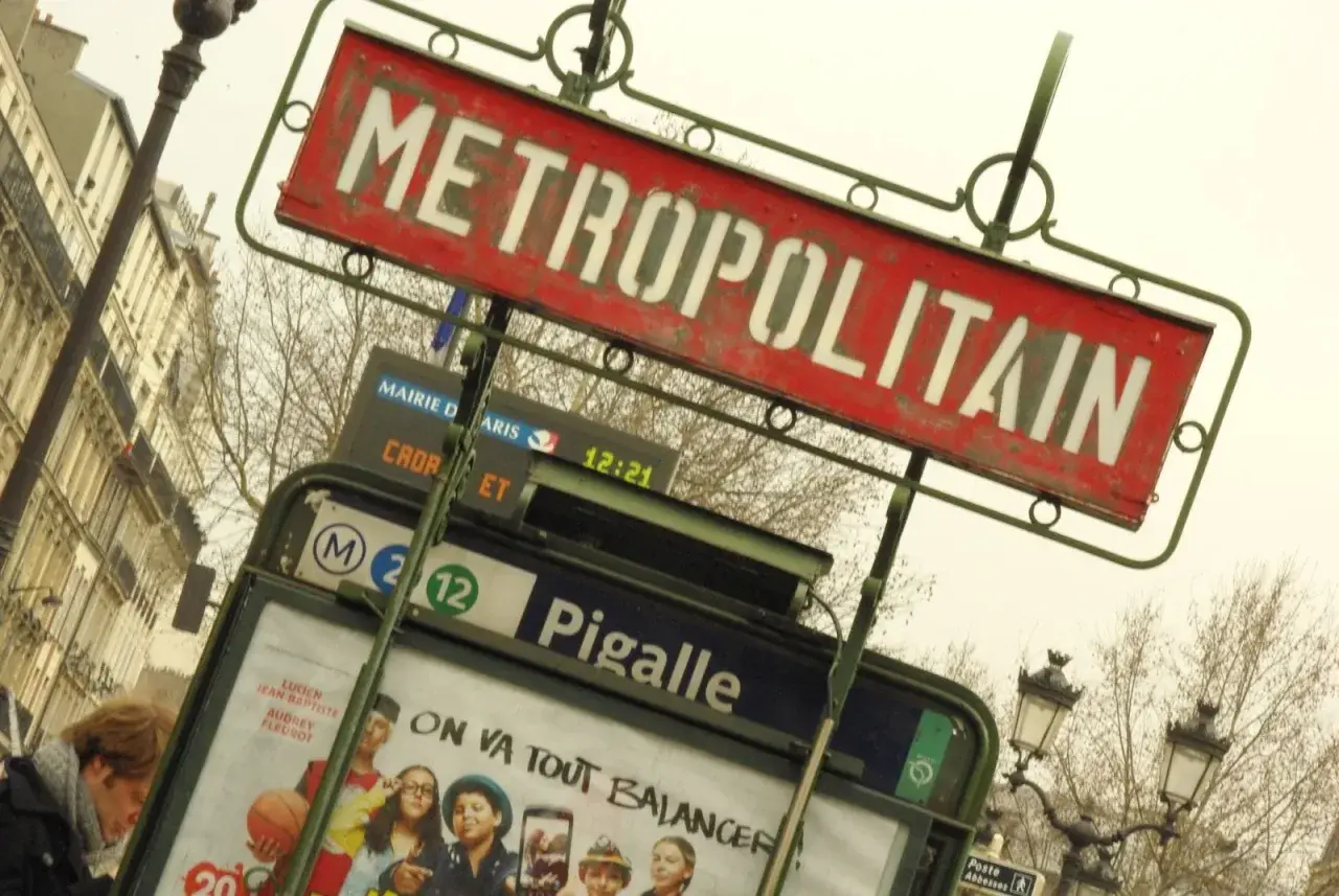 Znak stacji metra "METROPOLITAIN" w Paryżu, z widoczną nazwą stacji "Pigalle" i numerami linii.