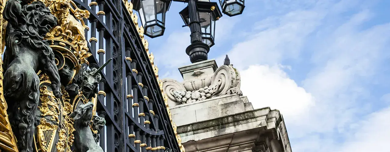 Złota brama i ozdobne lwy przed Pałacem Buckingham. Idealne miejsce na zwiedzanie!