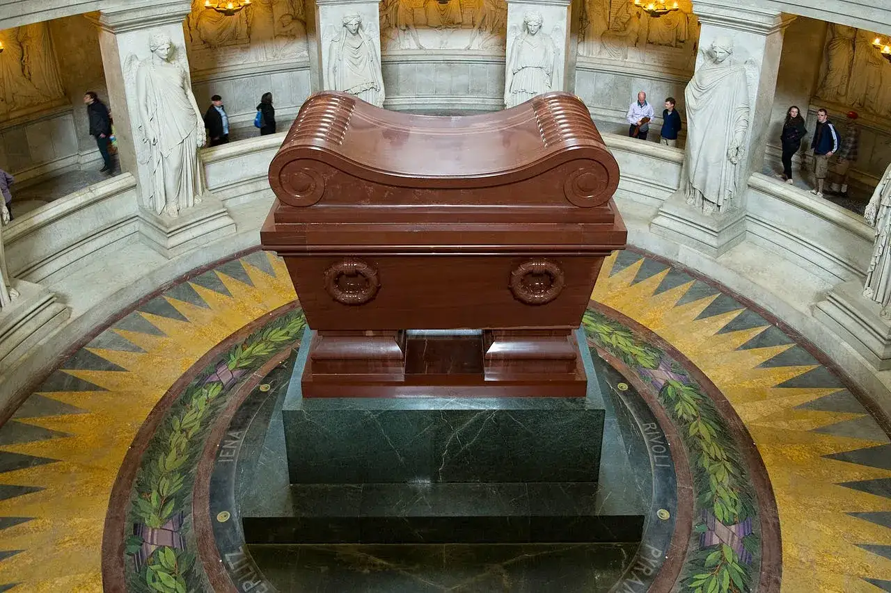 Grobowiec Napoleona w paryskim Invalides. Monumentalna, czerwona trumna spoczywa na marmurowym postumencie.