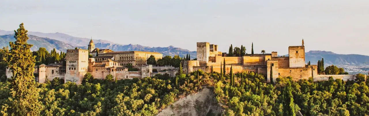 Alhambra, gdzie jest? To wspaniały kompleks pałacowy w Granadzie, Hiszpania, otoczony bujną zielenią i górami.