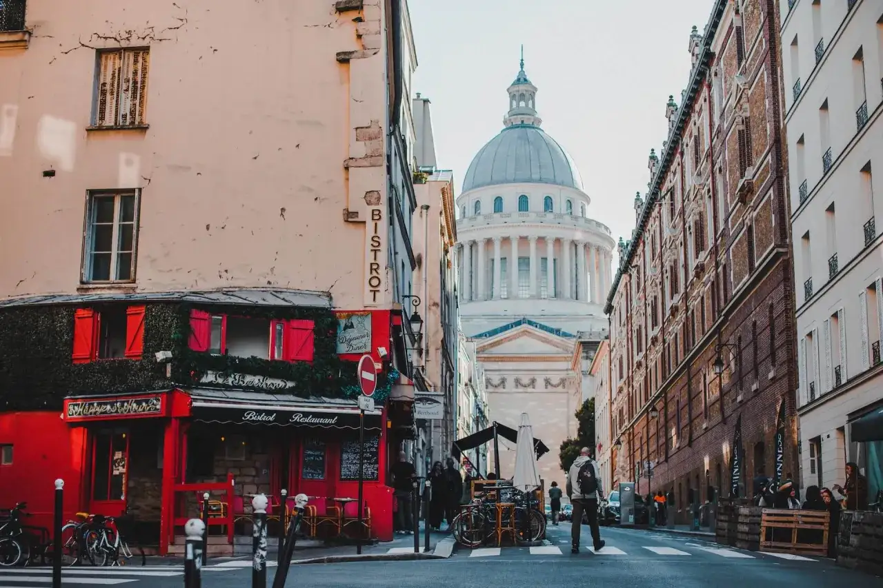Urokliwa ulica w dzielnicy łacińskiej Paryża z widokiem na Panteon. Czerwony bistrot zaprasza na kawę.