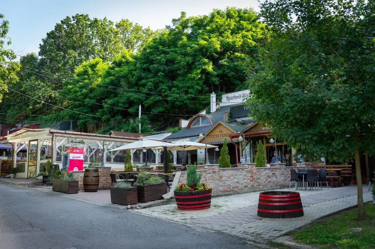 Urokliwe Eger i okolice atrakcje zachęcają do odpoczynku. Widać tu restauracje z ogródkami, zielone drzewa i kamienne detale.