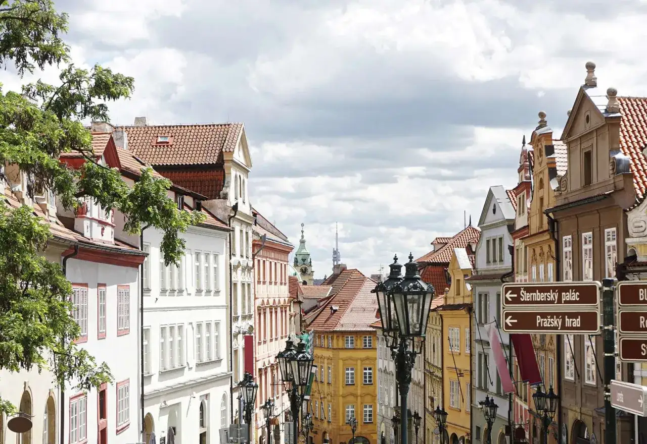 Urokliwa ulica w Pradze z zabytkowymi kamienicami i latarniami. Odkryj praga nietypowe atrakcje, kierując się znakami na Pražský hrad.