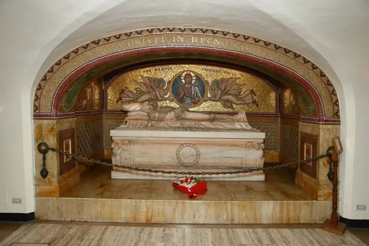Grobowiec w Grotach Watykańskich z mozaiką Chrystusa i aniołów. Marmurowa figura leży na sarkofagu, ozdobionym napisem.