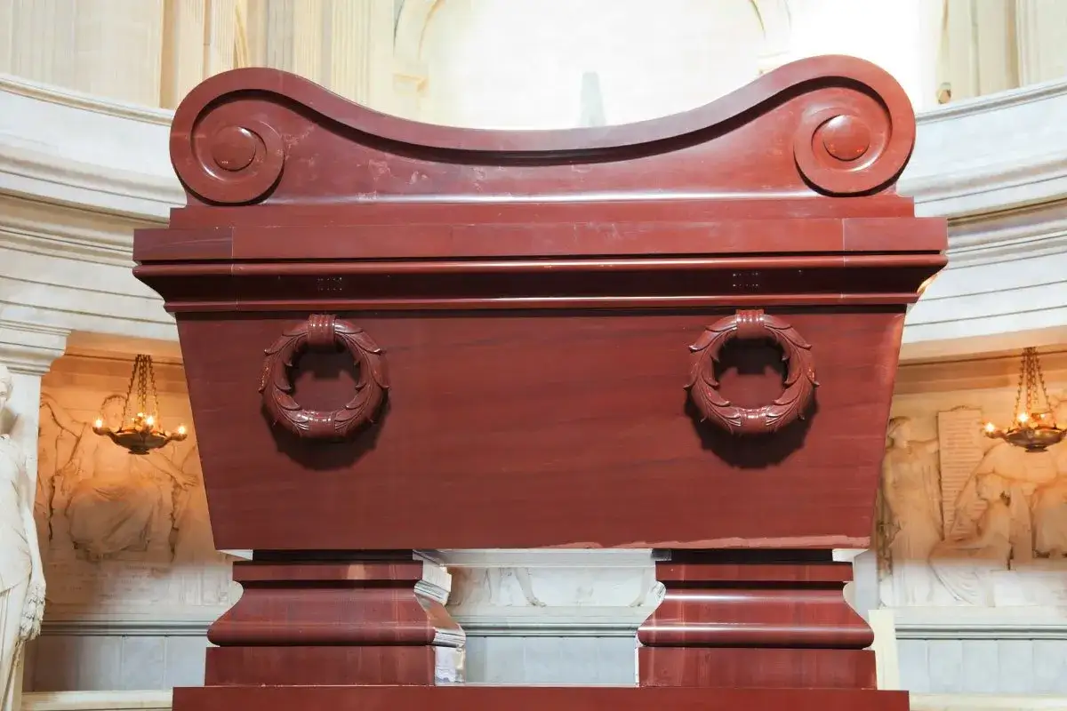 Imponujący, czerwony sarkofag z wieńcami laurowymi, miejsce spoczynku Napoleona Bonaparte.