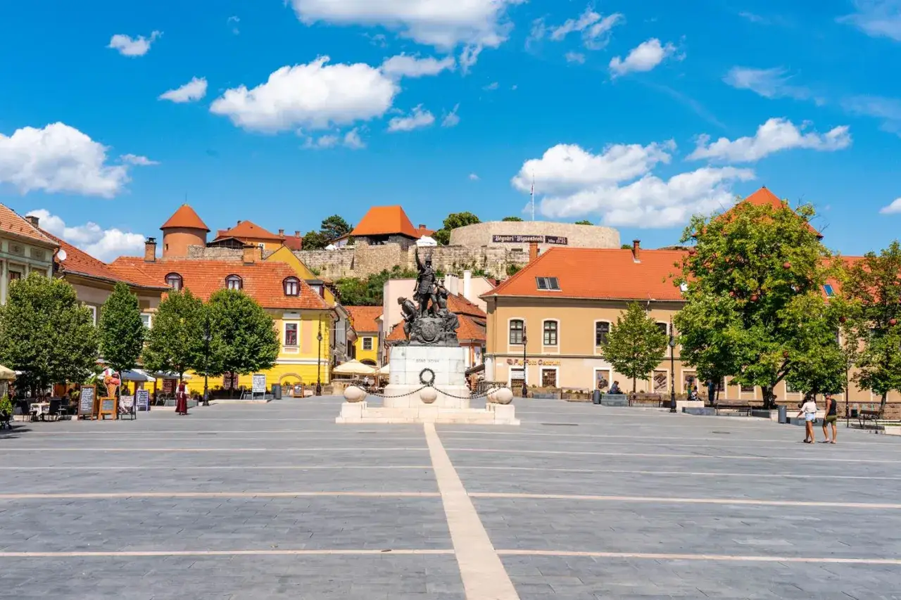 Eger i okolice atrakcje: Rynek z pomnikiem, zamkiem w tle i urokliwymi kamieniczkami.